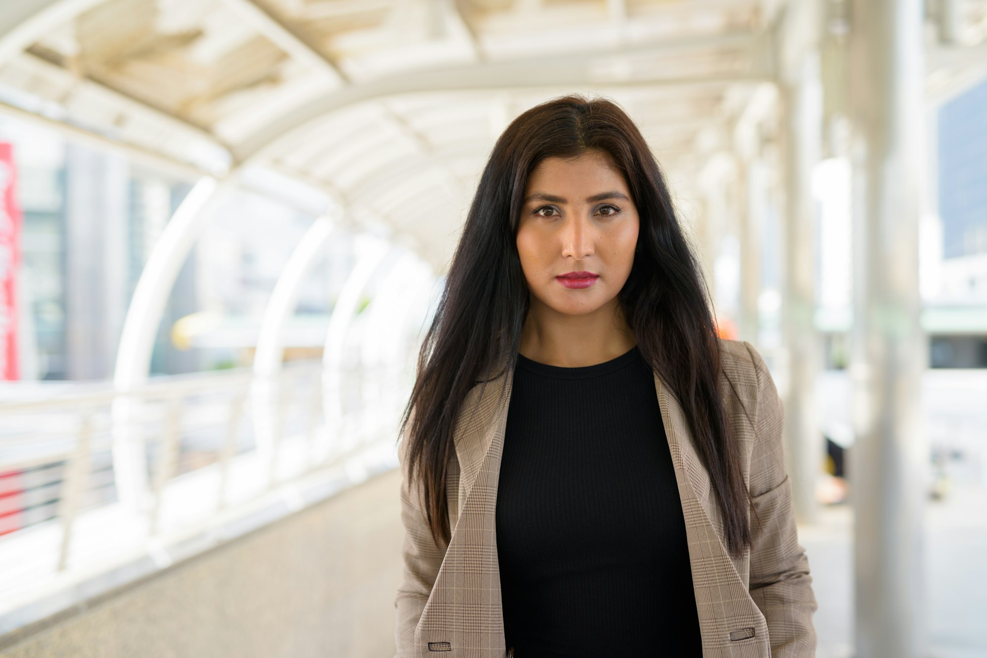 Young beautiful Indian businesswoman at footbridge in the city